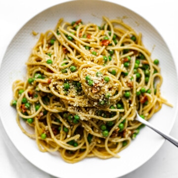 Over head photograph of a plate of curry pasta, Sprinkled with vegan parmesan.