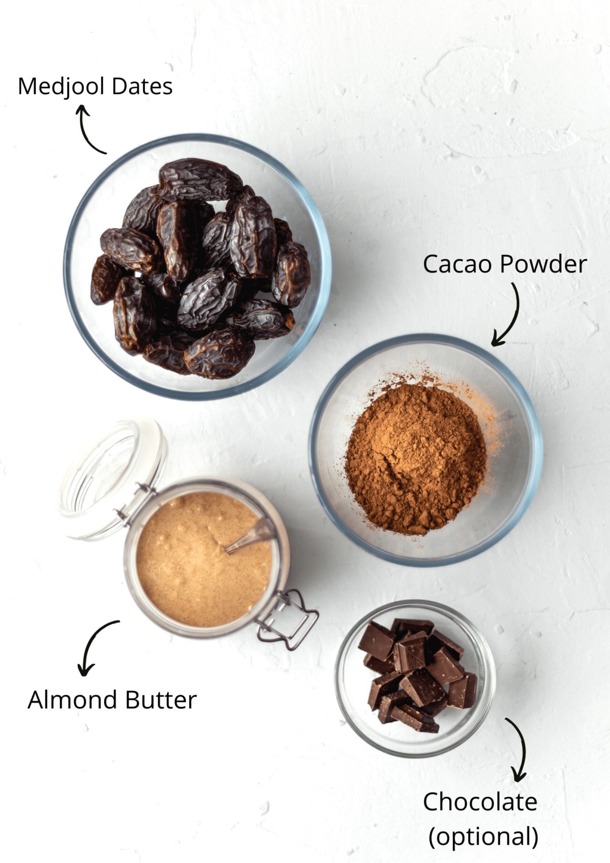 Overhead shot of glass bowls set out on a white background with the date brownie ingredients in them.