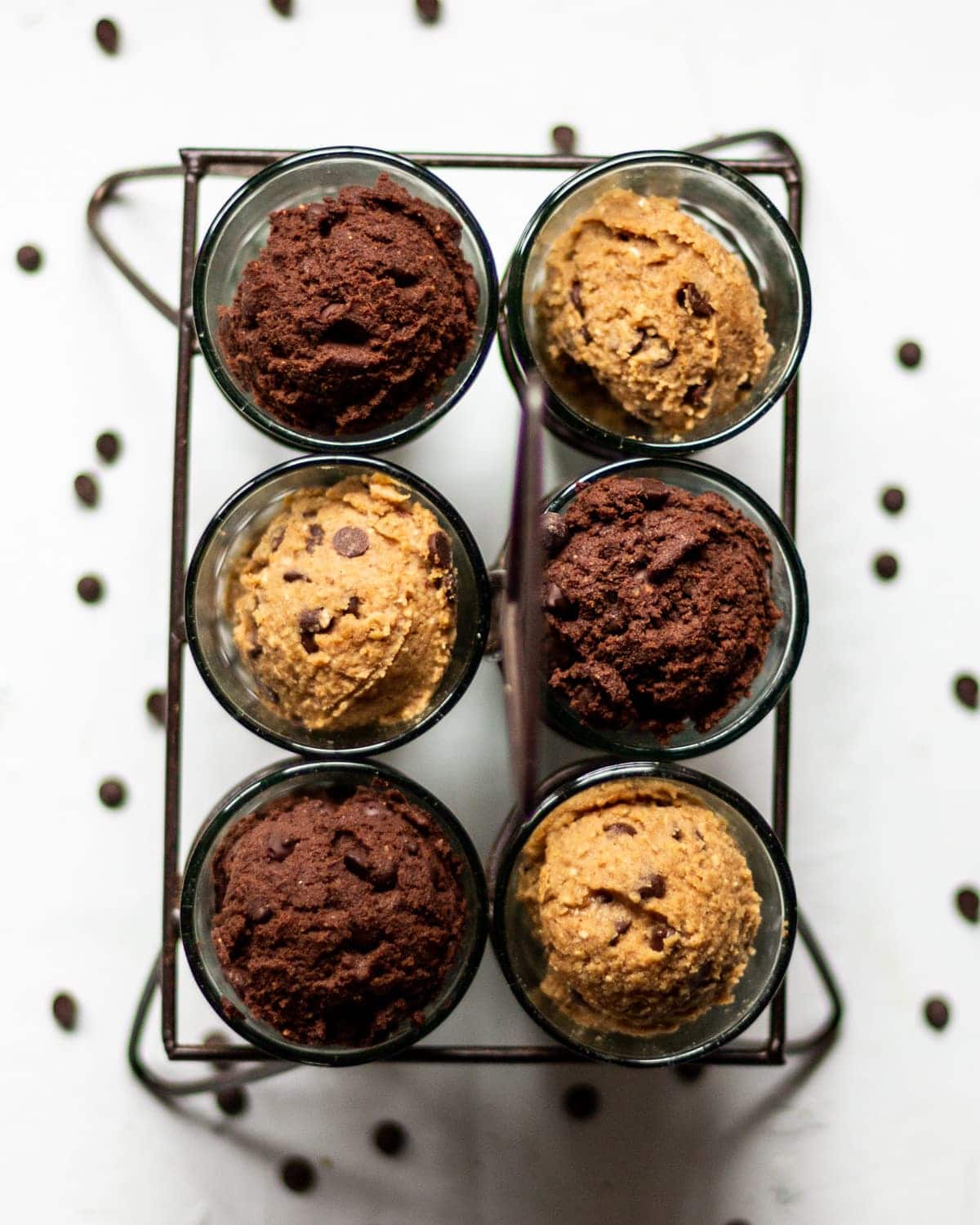 Side by side photos of the edible vegan chocolate cookie dough in a glass bowl on a white background, showing it before and after the chocolate chips are mixed in to the dough.