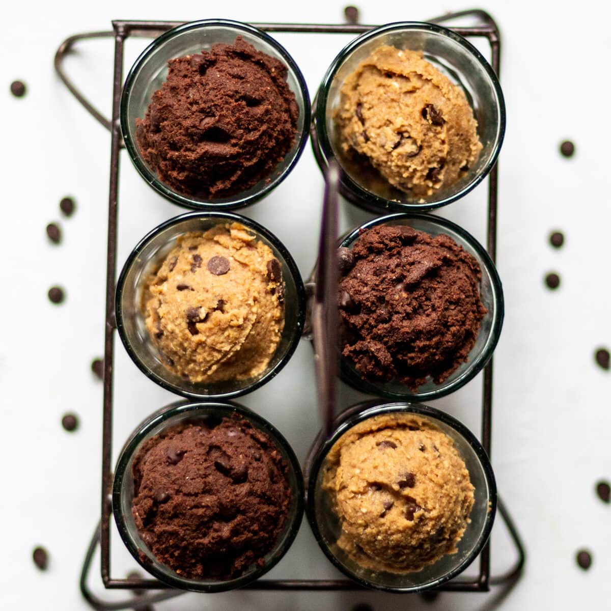 An overhead photo of regular cookie dough, and double chocolate cookie dough, in glasses, scooped in like ice-cream.