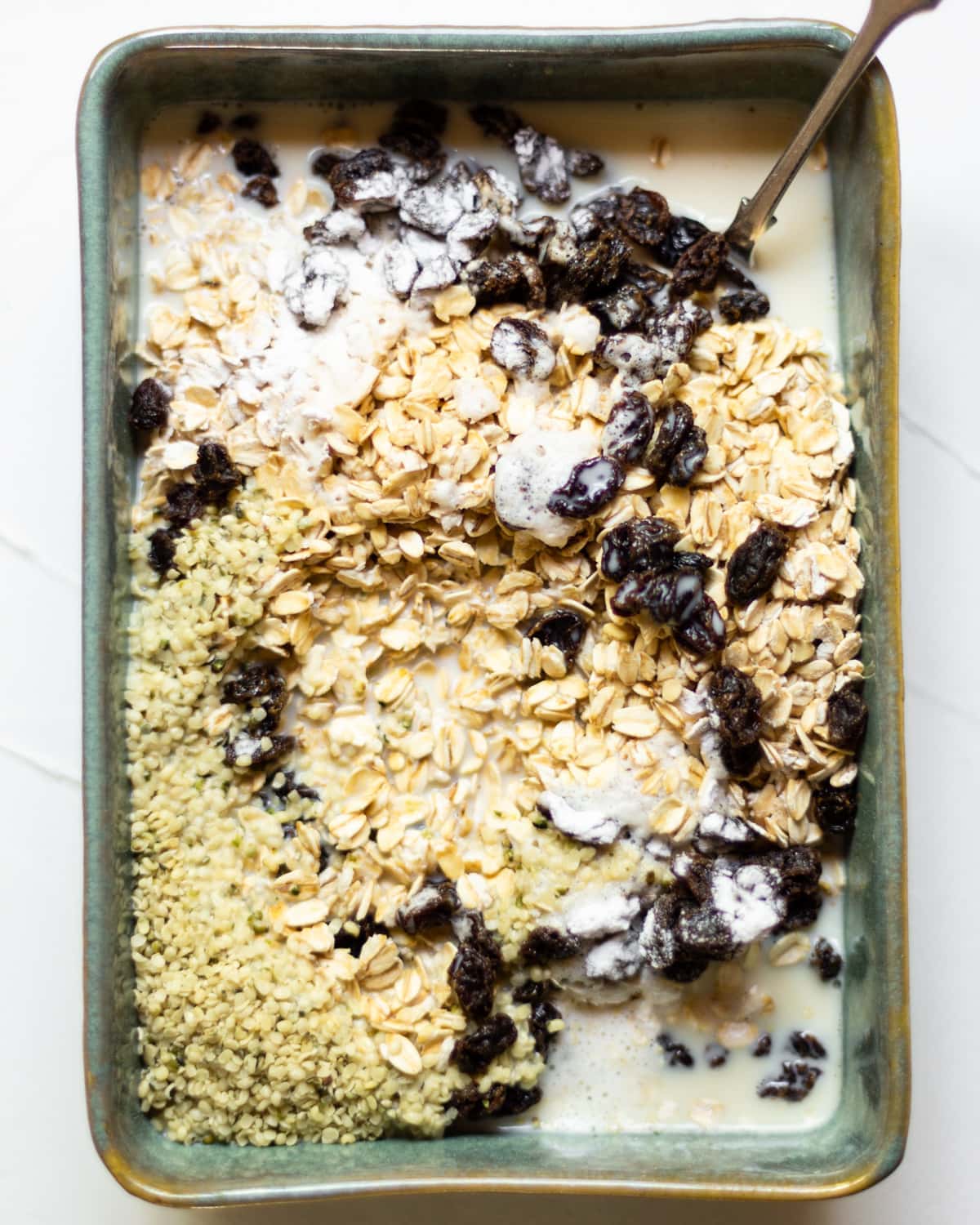 An overproof dish filled with all of the baked oats ingredients, except the berries, before mixing together.