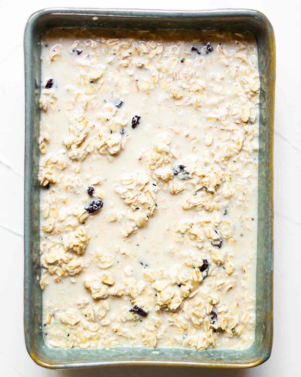 All baked oat ingredients mixed together in an ovenproof dish.