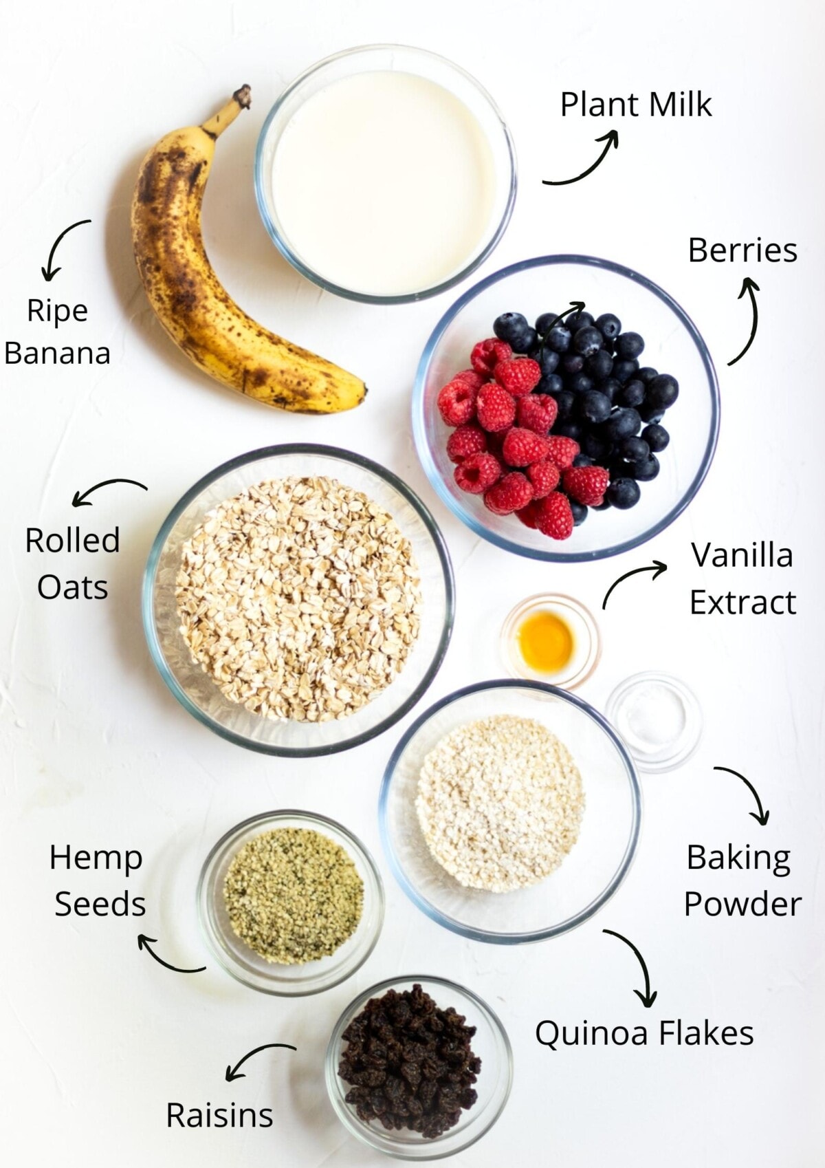 The baked oats ingredients laid out in bowls on a white background and labelled.