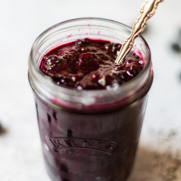 A glass jar filled with blueberry chia jam.