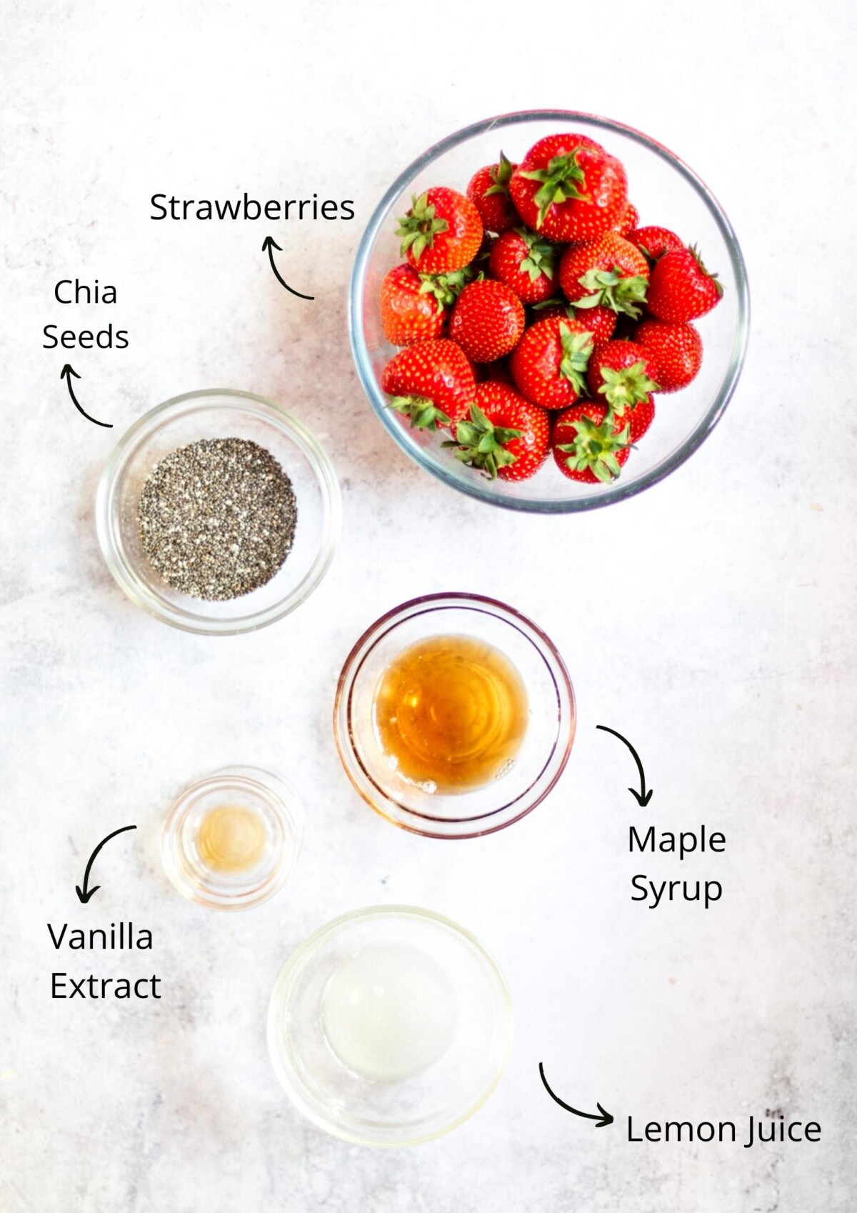 The strawberry chia jam ingredients laid out on a white board and labelled.